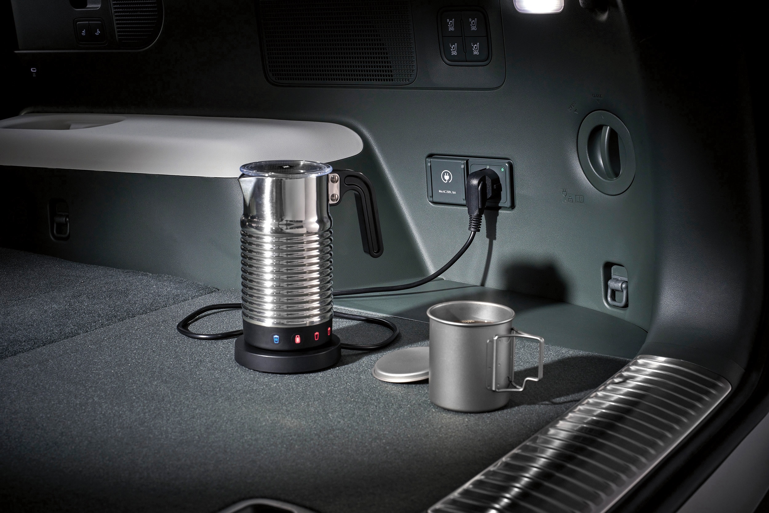 Onboard power socket in the boot of the Hyundai IONIQ 9 electric SUV powering a coffee maker.